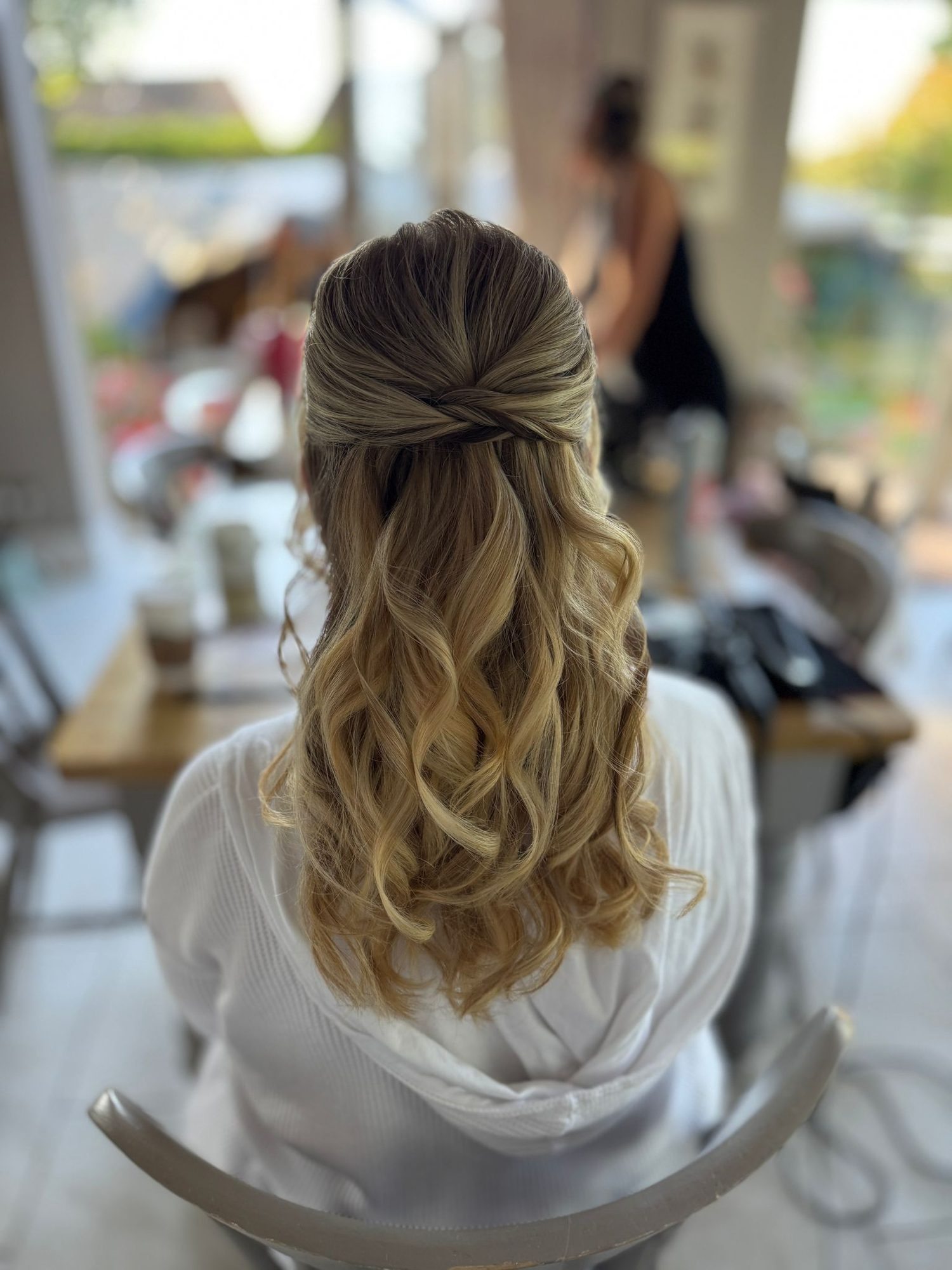 Elegant half-up bridal hairstyle with soft curls by Lucent Hair